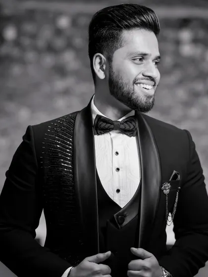 A classic black and white portrait of the groom. His confident smile and sharp tuxedo are captured in this timeless, dapper shot.