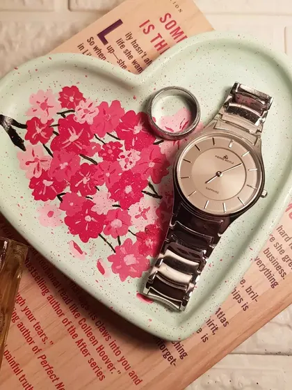 Our hand-painted cherry blossom heart tray, styled with a watch and ring. It shows how a functional item can also be a stunning piece of decor.