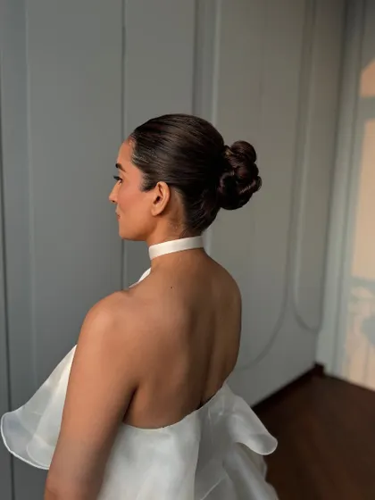 A side profile of the sleek, modern bun. This hairstyle is all about clean lines and sophistication, perfect for a minimalist bride or a high-fashion event.