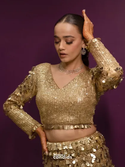 A glamorous portrait of the bride in her shimmery gold reception outfit, showcasing her confidence and style.
