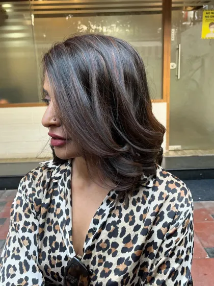 A side view of the balayage on her medium-length hair.