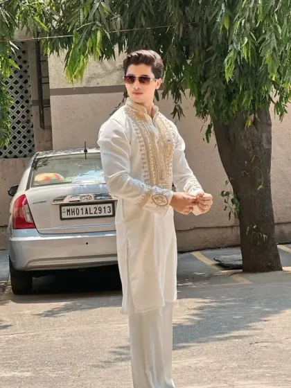 An all-white kurta set with gold embroidery, a timeless choice for festive occasions.