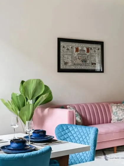 This open-plan villa design shows the seamless flow between different living areas. The pink and blue sofas add pops of color to the neutral, modern space.