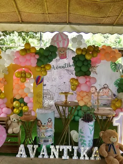 This world map themed party was set up outdoors under a canopy. The decor features hot air balloon props, teddy bears, and a colorful balloon arrangement for a fun adventure theme.