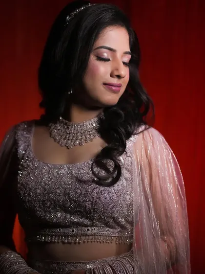 A professionally shot portrait for a reception. The makeup features a soft glittery eye and a subtle pink lip, which looks beautiful with her embellished lehenga and diamond necklace.