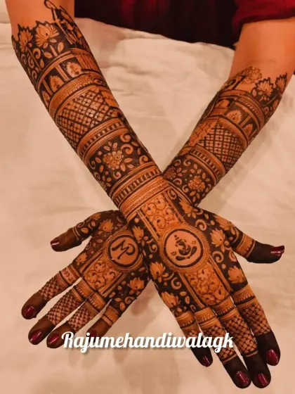 A beautiful bridal design with a Ganesha motif and the couple's initials hidden in the palm. The arms are filled with floral and geometric patterns.