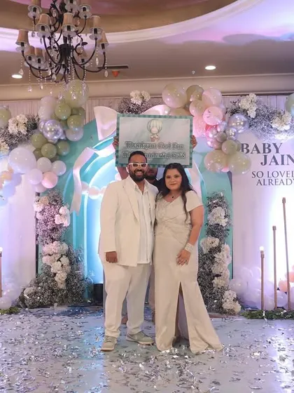 The parents-to-be looking radiant amidst a shower of confetti on their beautifully decorated stage.