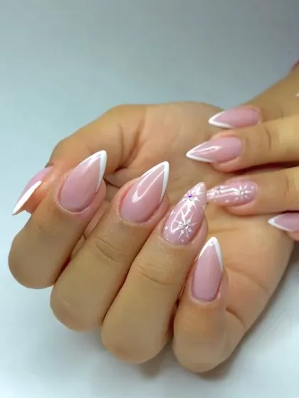A sharp and chic V-cut French manicure, also known as a chevron tip. We added a subtle snowflake design to one nail for a touch of winter magic.