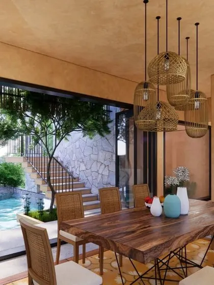 The dining room at Earth Abode, where foldable glass doors open up the entire wall, merging the interior dining space with the outdoor pool and garden.