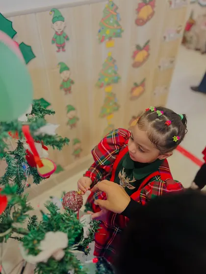 A toddler gets a helping hand to hang an ornament, a sweet moment of teamwork during our Christmas preparations.