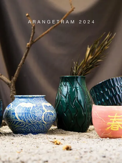 Srishty, a Japanese language expert, explores texture through slip work and carvings in her Arangetram collection. Using a vibrant color palette, she creates functional and decorative hand-built and wheel-thrown pieces, including vases, mugs, and ramen bowls.