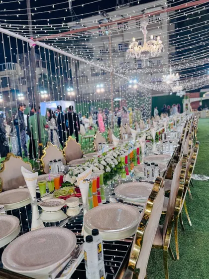 An elegant long-table dining setup for a large corporate event. The mirrored tabletops, sophisticated floral arrangements, and ambient fairy lights reflect the premium atmosphere I create.