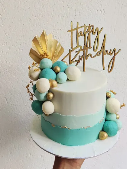 This teal and gold beauty is modern and chic. The ombre teal finish is complemented by a cascade of edible spheres and a touch of gold leaf, perfect for a stylish birthday celebration.