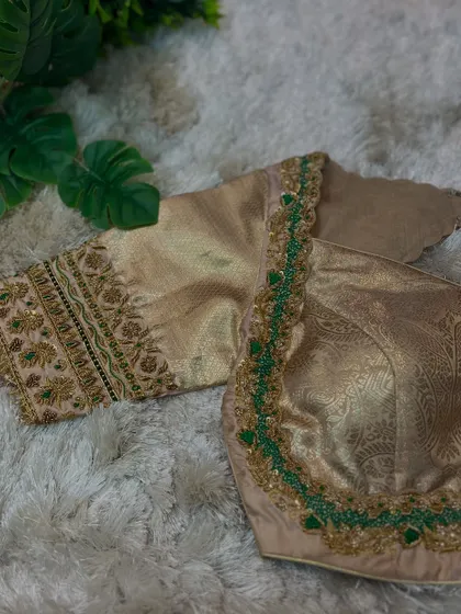 A side view of the beige and green blouse, showing the elegant scalloped neckline.