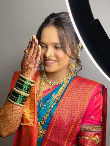 A happy bride posing with her ring light. This shot captures the flawless finish of her HD makeup, designed to look perfect both on and off camera.