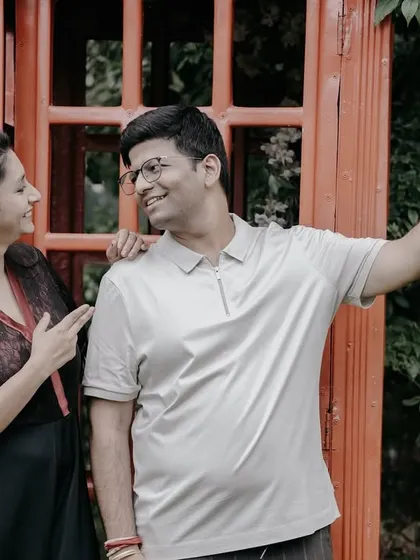 A fun, modern take on a pre-wedding photo, with the couple taking a selfie in front of a classic red telephone booth.