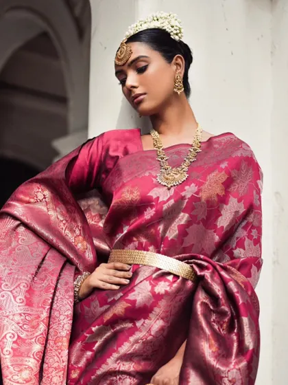 A regal pose in a magenta Banarasi silk saree. The styling focuses on the luxurious fabric and traditional jewellery, creating a powerful and timeless image of Indian elegance.