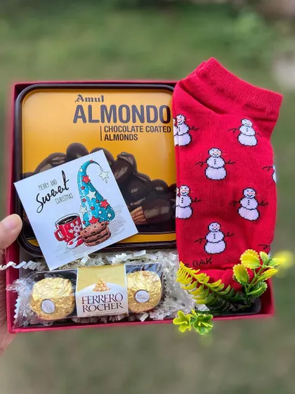 A sweet and simple Christmas treat. This hamper includes a tin of Amul chocolate-coated almonds, a pair of festive snowman socks, and Ferrero Rocher chocolates, making it an ideal stocking stuffer or Secret Santa gift.