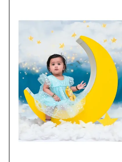 This little girl in a simple blue dress looks so peaceful in this 'Moon & Stars' setup. These sessions are designed to be calm and comfortable for your baby.