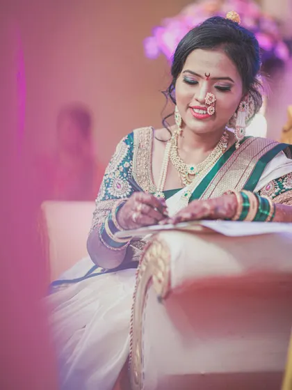 A candid moment of the bride signing her marriage documents, a significant and emotional part of the wedding day.