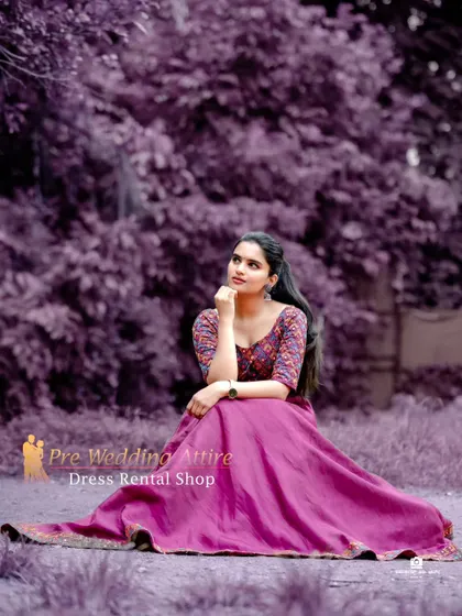 A seated pose in the magenta skirt and printed top, showing the full volume of the skirt.