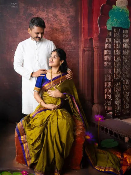 A portrait of togetherness. The couple shares a gentle look, framed by a setting that speaks of Indian heritage and artistry, making for a truly special maternity memory.
