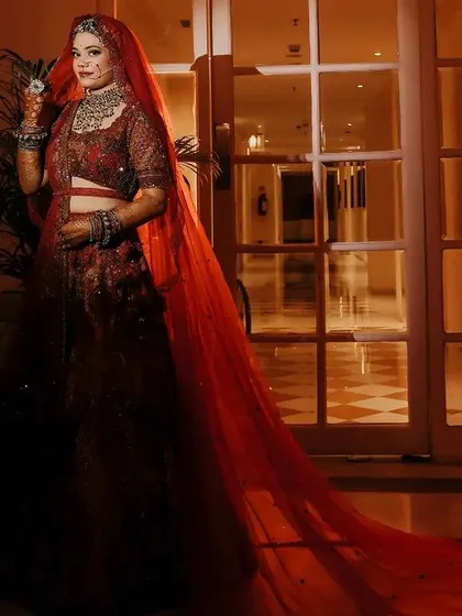 A dramatic portrait of the bride with her long red veil, creating a striking and artistic image.