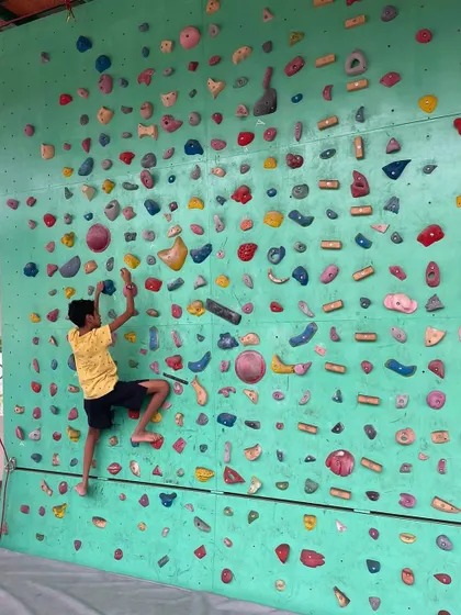 A young explorer scales our colorful bouldering wall. Each climb is a new puzzle to solve, building resilience and confidence one hold at a time.