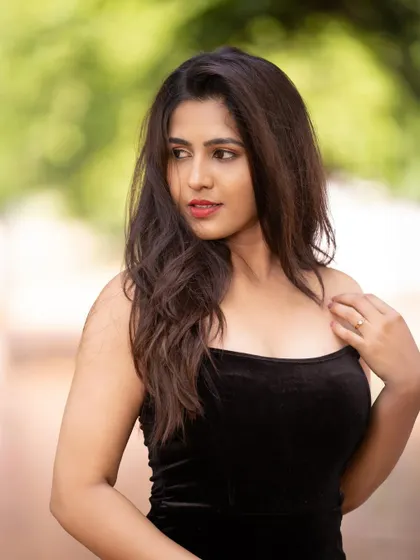 A softer portrait of Apurva, capturing a moment of quiet elegance amidst the trees.