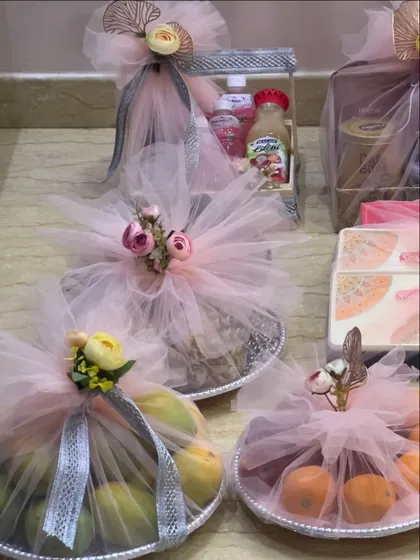 A collection of trousseau items ready for delivery. I use pearl-lined trays for fruits and wrap everything in soft pink tulle to create a delicate and romantic feel for the bride's belongings.