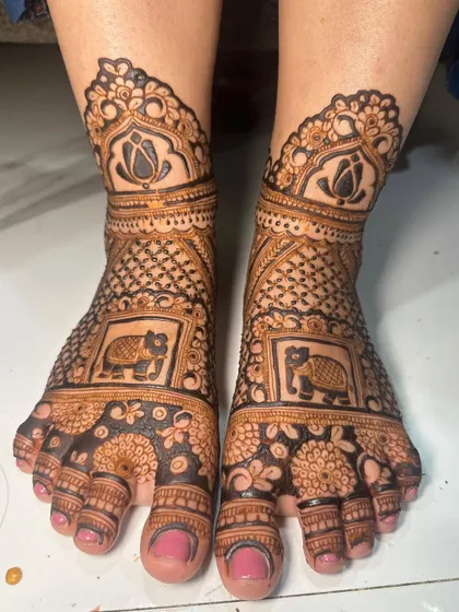 Bridal feet with an elephant motif inside a frame, surrounded by floral and geometric patterns.