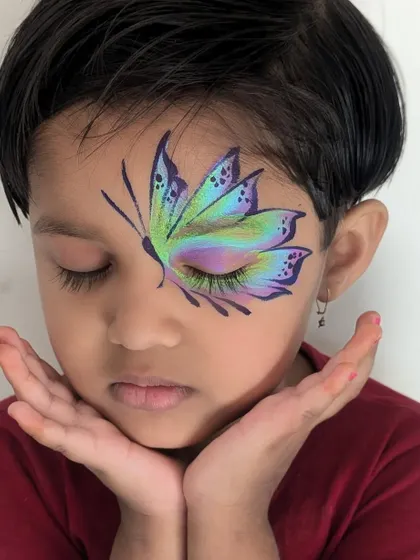 This intricate butterfly design is one of my most requested pieces for children's parties. I use multi-color cakes and fine brushes to create this beautiful, blended effect that looks magical when kids flutter their eyes.