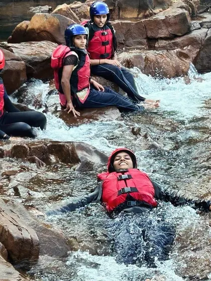 A participant relaxes in a small cascade, a refreshing and fun part of our river expeditions in Dandeli.