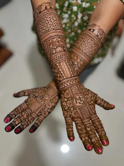 A crossed-hands pose of the complete "MS" bridal design.