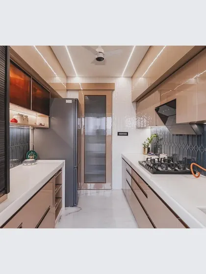 This wide shot shows the entire length of the parallel kitchen, from the cooking hob on one side to the refrigerator and storage on the other, demonstrating a highly functional work triangle.