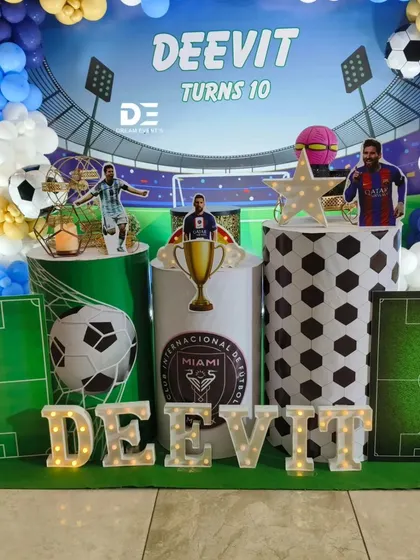 A football fan's dream come true. This setup for a 10th birthday includes a stadium backdrop, balloon arrangements in team colors, and cutouts of star players.