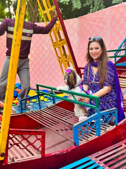 It is not just about blessings, it is about fun too. A pet parent and her Shih Tzu enjoy a ride on a colorful mini boat swing at the event venue.