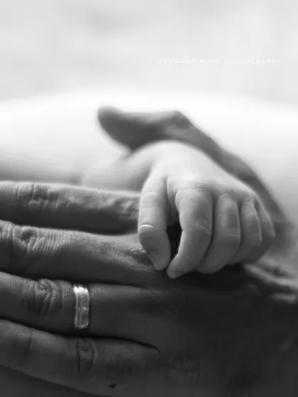 The powerful connection of a tiny hand wrapped around a parent's finger. This black and white close-up is one of the most requested and cherished shots in newborn photography.