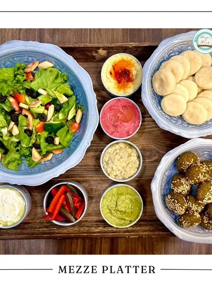 A beautiful Mezze Platter, ideal for a festive Rakhi celebration. This platter is packed with falafel, various dips, salad, and mini pitas, offering a taste of the Mediterranean.
