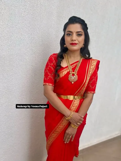A full view of this striking red saree look. The makeup is bold yet elegant, creating a confident and sophisticated appearance perfect for any celebration.