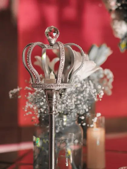 This detail shot highlights the royal-themed accents, like this miniature silver crown candle holder. These small, thoughtful touches contribute to the overall narrative of elegance and luxury.