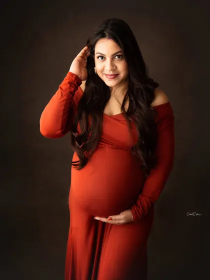 A simple, beautiful portrait focusing on the mom-to-be's happy expression and her gorgeous off-the-shoulder orange gown.
