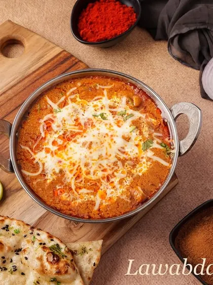 Lawabdar Chicken is a rich and creamy Mughlai gravy dish. Tender chicken pieces are cooked in a luscious tomato-based sauce, finished with cream and cheese, perfect with naan or roti.
