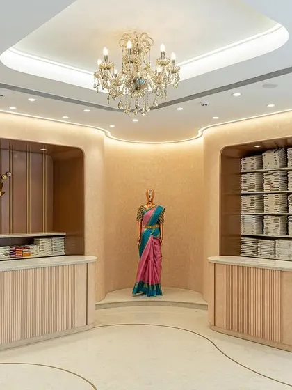 The entrance lobby of the Nalli store, designed as a hybrid retail and visual merchandising space. The curved counters and soft lighting create an elegant and welcoming first impression.