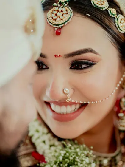 A beautiful, happy moment between the couple. The bride's makeup is soft and romantic, with a focus on a natural, radiant glow.
