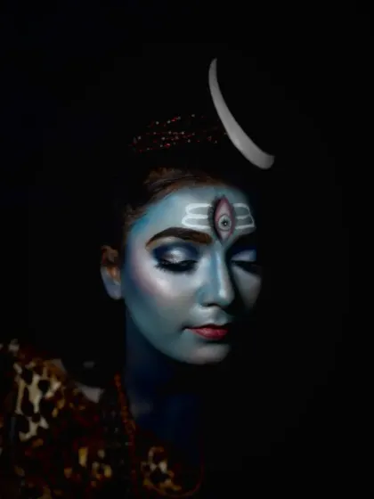 A serene, eyes-closed pose that highlights the flawless blue base and the precision of the forehead markings in this Mahadev makeup look.