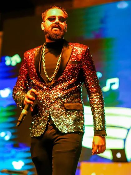 Our rockstar vocalist in his element, wearing a dazzling two-tone sequin jacket. Our look is as much a part of the show as our music.