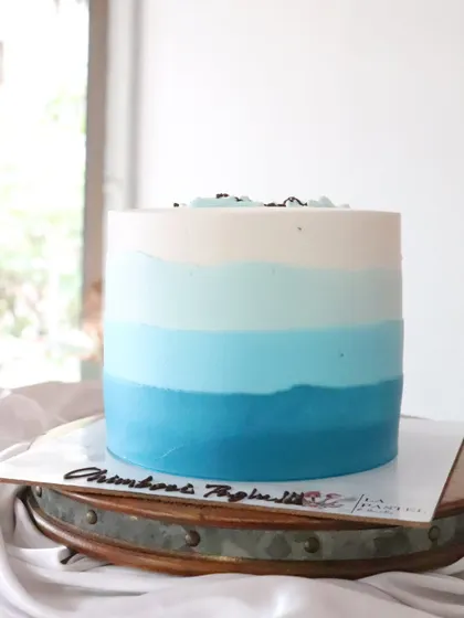 I love creating ombre effects with frosting. This cake features beautiful layers of blue, fading from a deep shade at the bottom to pure white at the top, like the ocean or the sky.