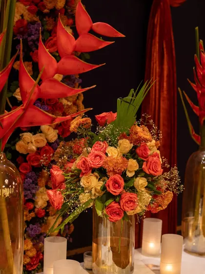 A close-up of one of the floral arrangements, featuring birds of paradise, roses, and other blooms in warm, fiery tones that matched the Diwali theme.
