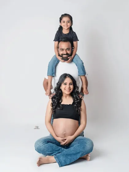 A fun and playful family portrait! This human totem pole is a creative way to show the love and connection in a growing family during a casual studio shoot.